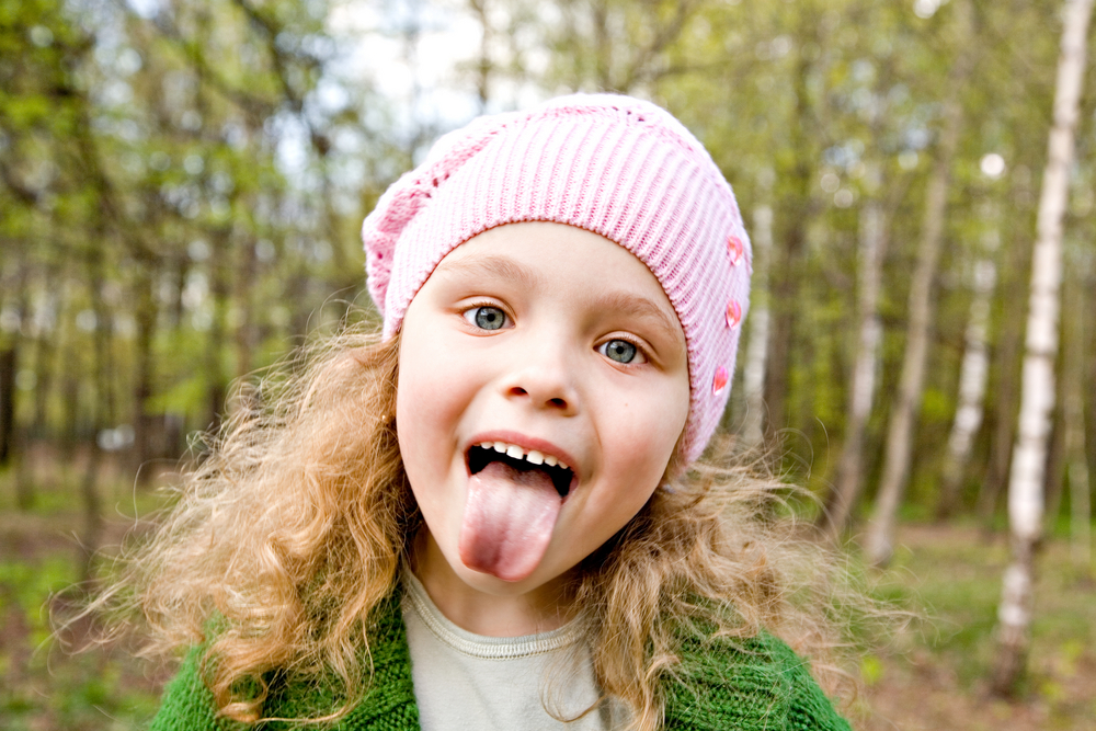 Cheerful,Little,Girl,In,A,Pink,Cap,Puts,Out,The