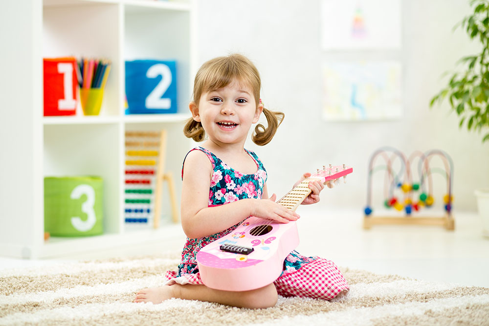 Kid,Girl,Playing,Guitar,Toy,At,Home